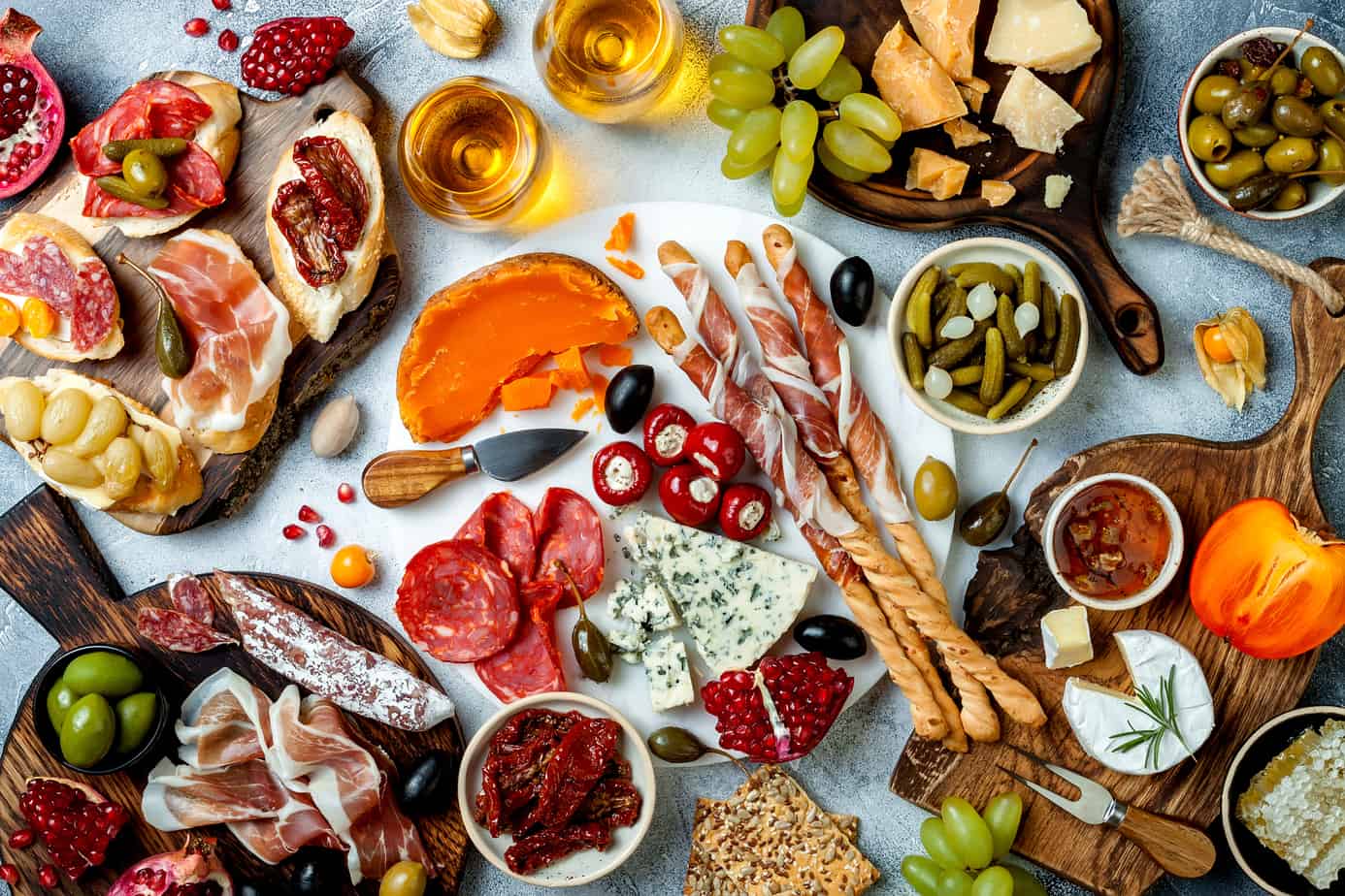 assorted charcuterie, pickled vegetables, and cheeses on a grazing tables